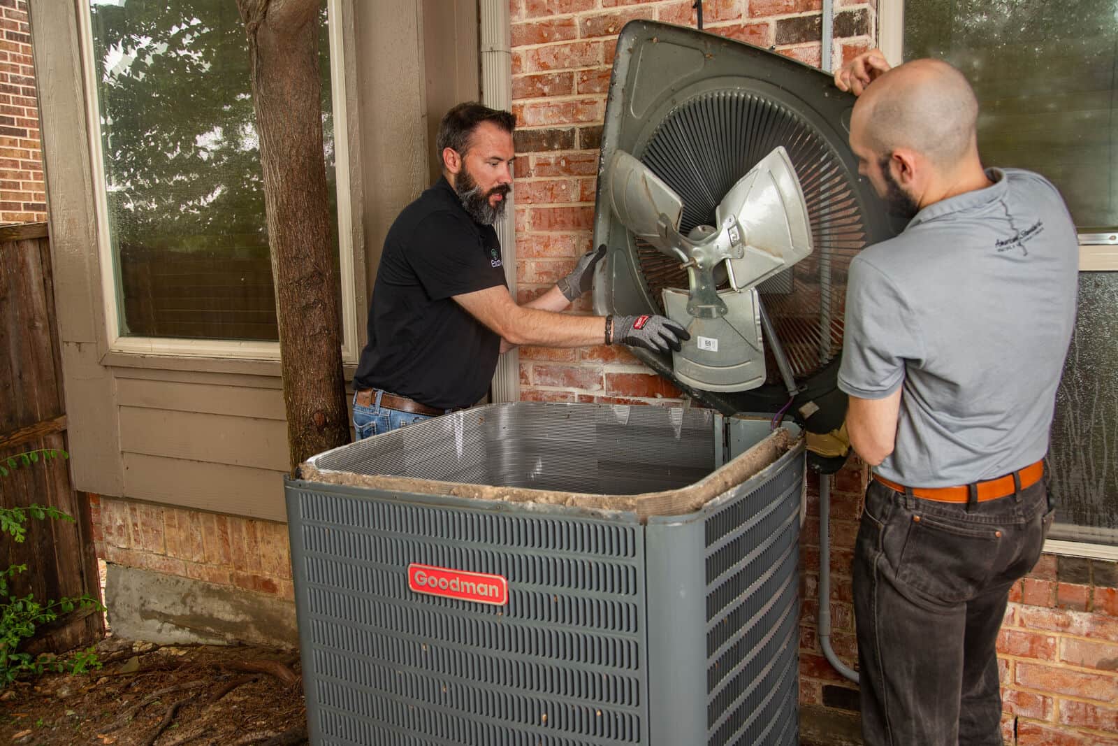 Team Enoch technicians installing an outdoor condenser unit