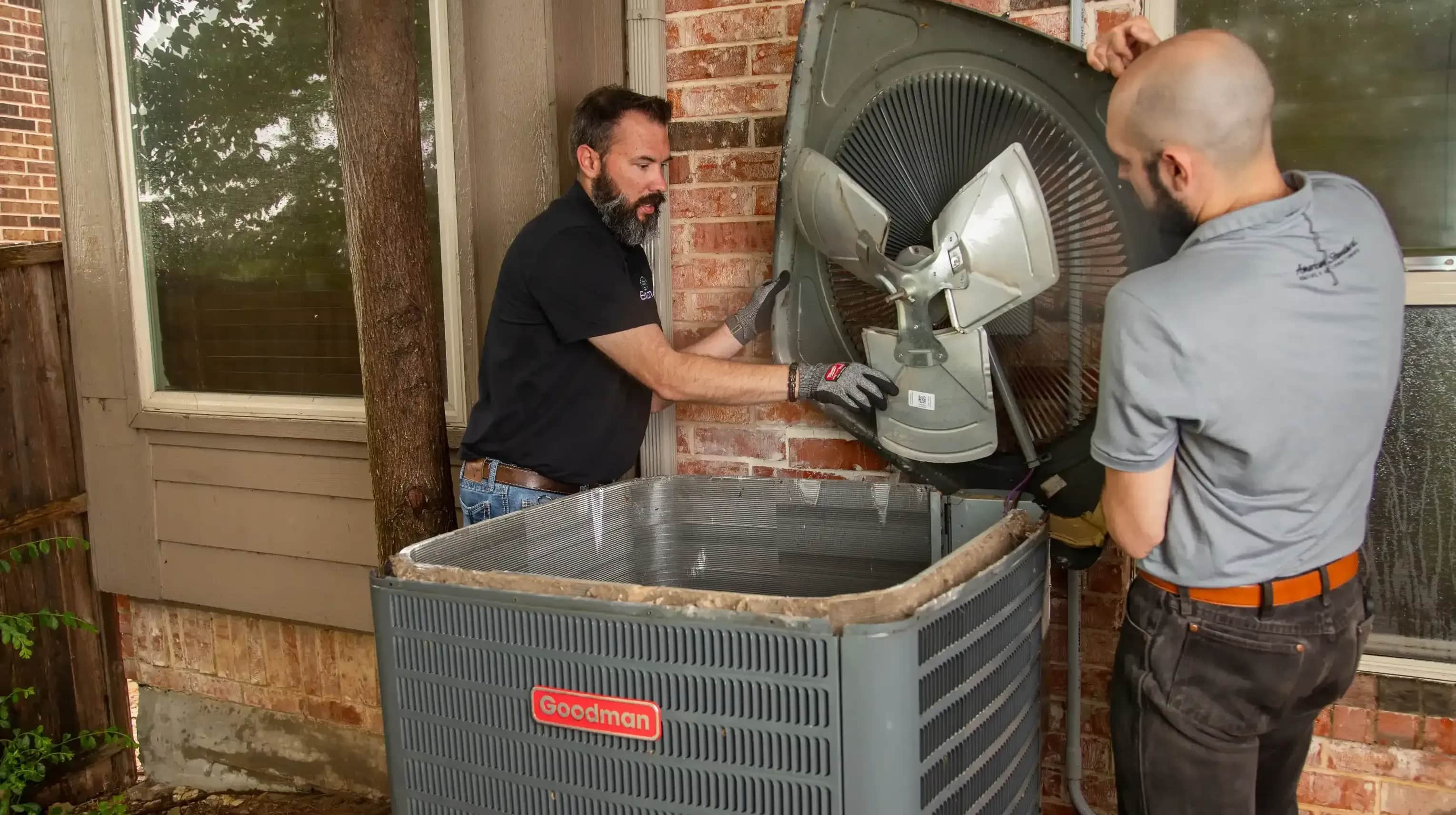Technicians servicing HVAC system