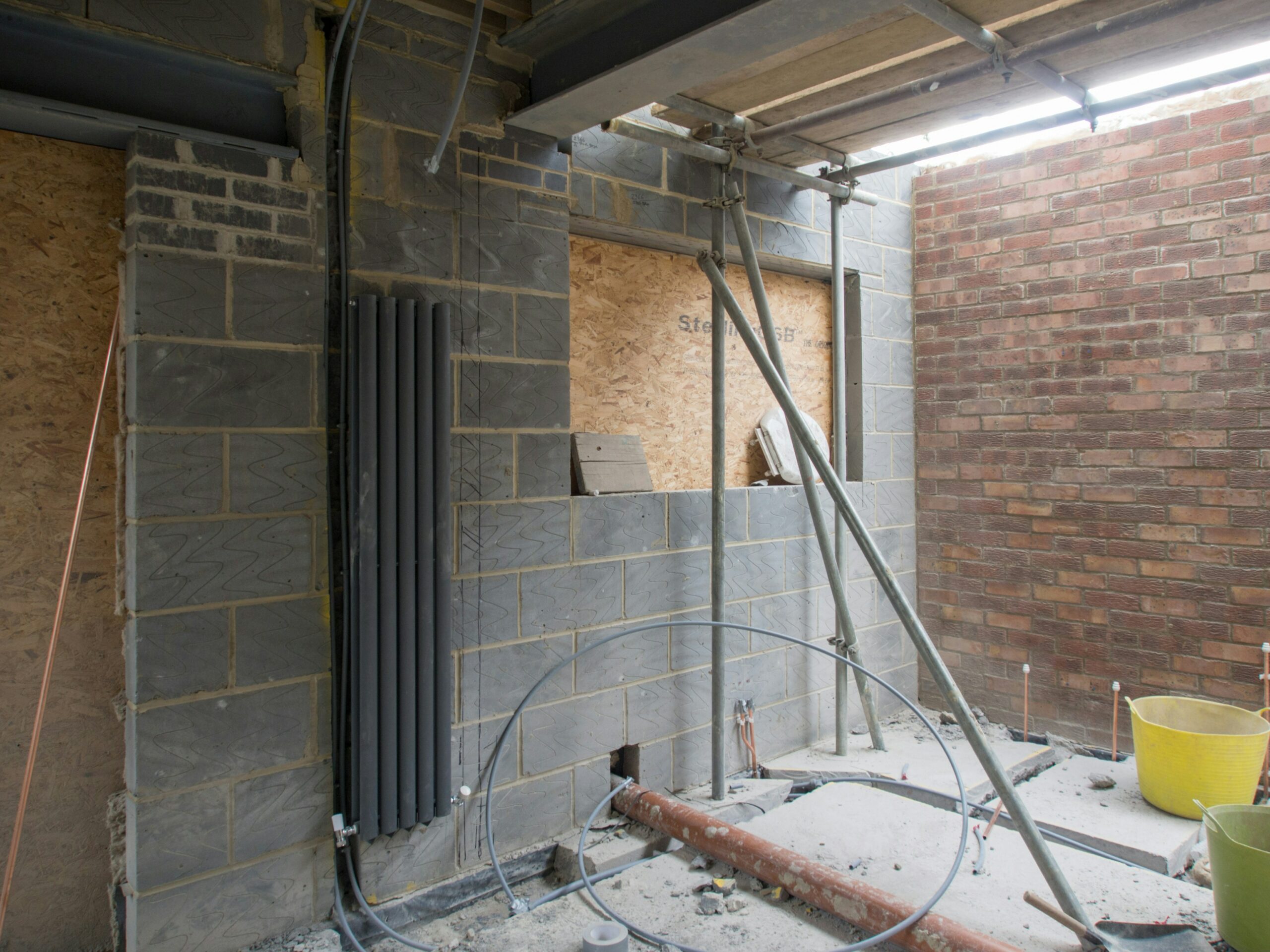 metal pipes against brick wall under construction